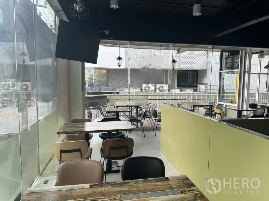Retail Space for rent in Khlong Toei, Bangkok - Corner dining area with glass walls, mixed seating and city views in a retail space near BTS.