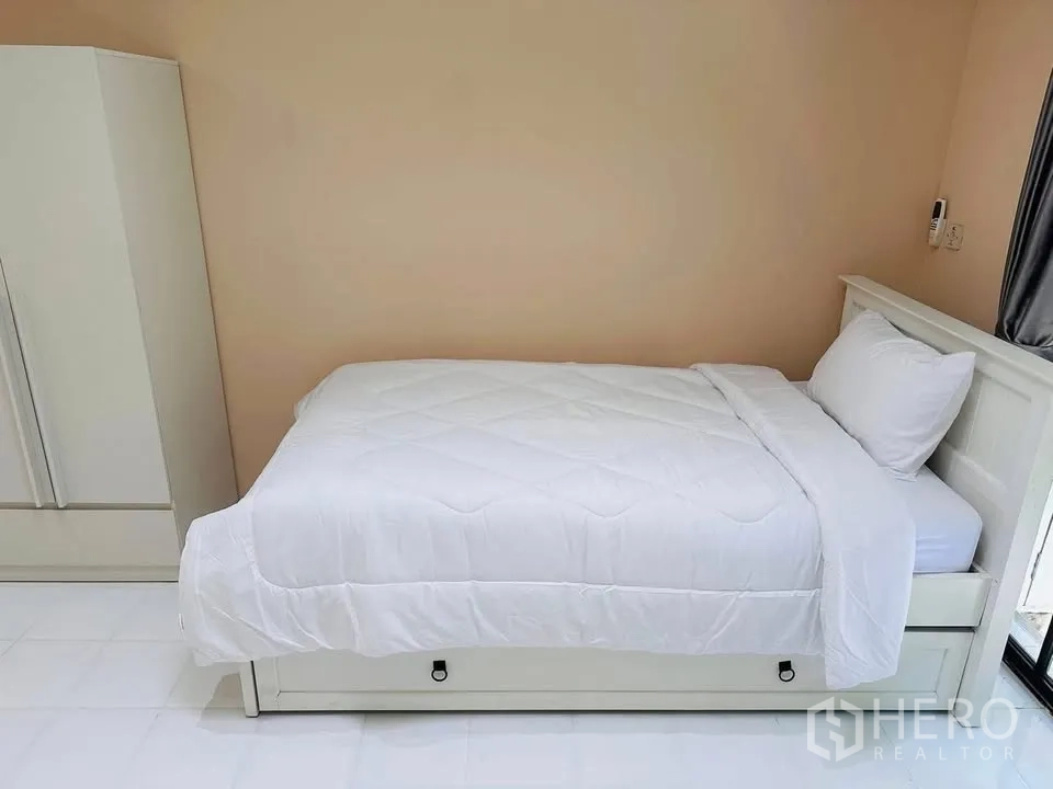 Townhouse for rent - Compact bedroom with a white single bed and wardrobe against a neutral wall.