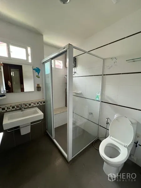 Detached House for rent in Bang Kapi, Bangkok - Modern bathroom with glass shower enclosure, white tiles and natural light.