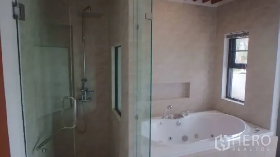 Detached House for rent in Watthana, Bangkok - En-suite bathroom with glass shower beside a built-in whirlpool bathtub and tiled walls.