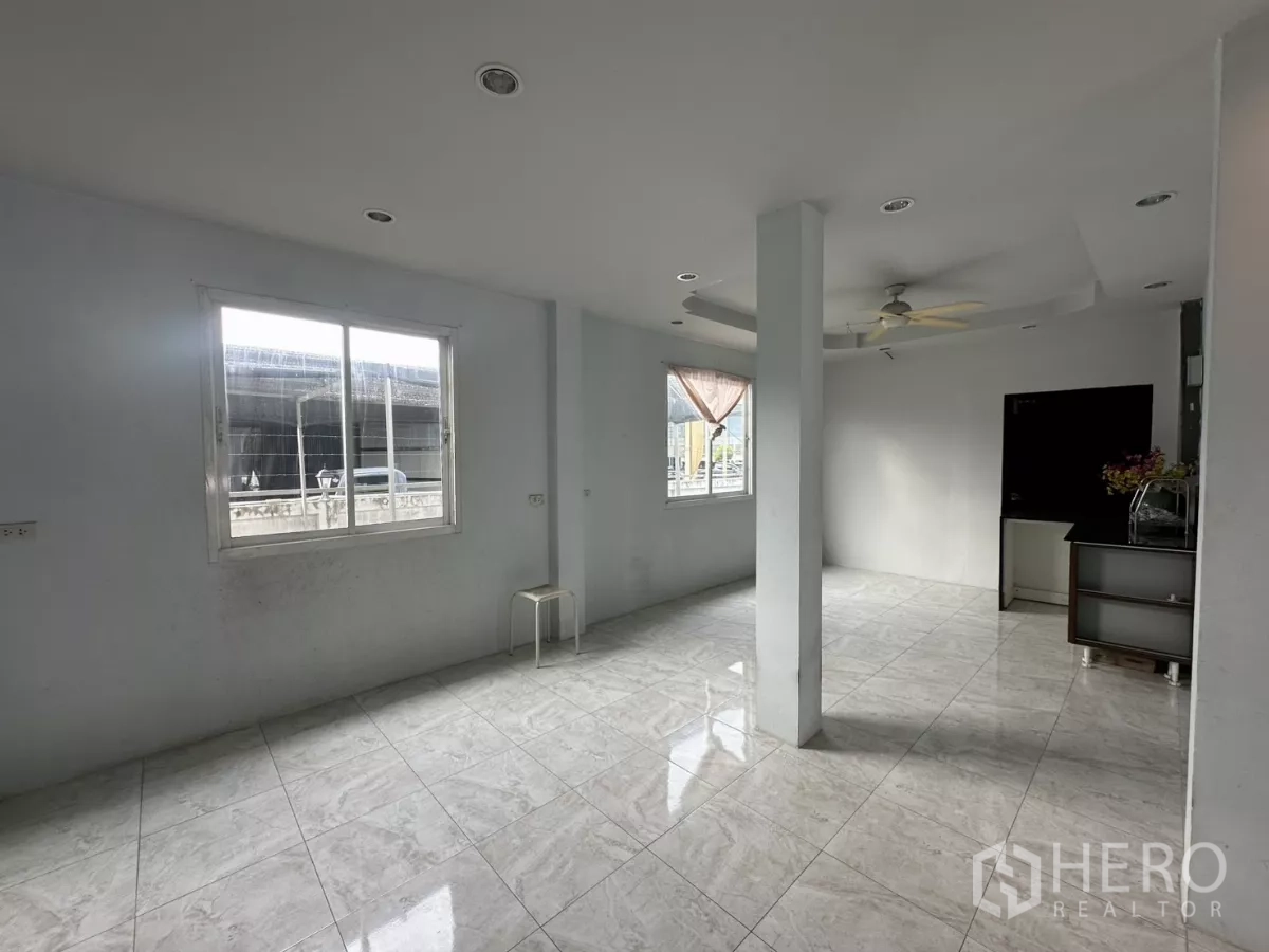 Home Office for rent - Upper-floor multipurpose area with windows, a column and ceiling fan.