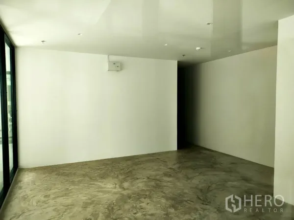 Retail Space for rent in Khlong Toei, Bangkok - Empty retail interior with white walls and polished concrete flooring, ready for fit-out.