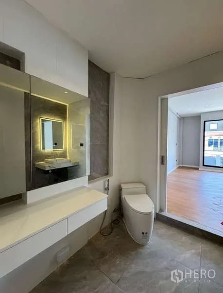 Townhouse for rent or sale in Prawet, Bangkok - Ensuite bathroom with floating vanity, smart toilet, and sliding door to bedroom.
