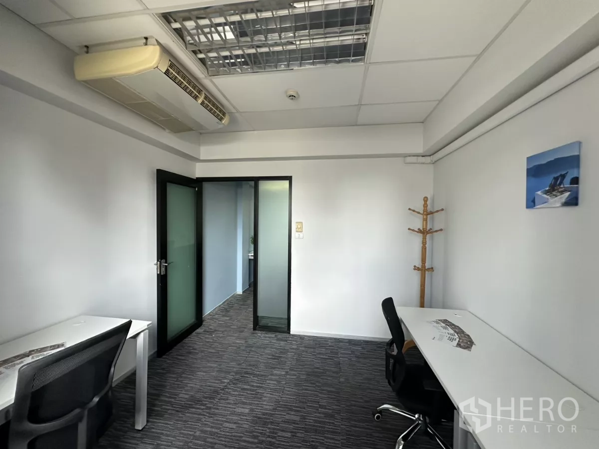 Office Space for rent in Watthana, Bangkok - Compact private room with desks, mesh chairs, frosted-glass door and ceiling air-conditioning.