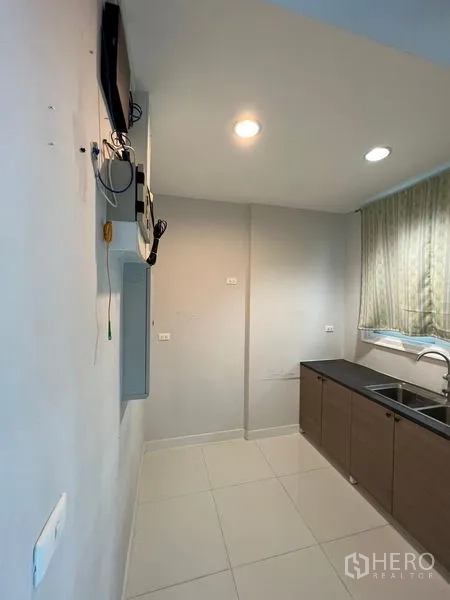 Home Office for rent or sale - Compact closed kitchen with window, sink and base cabinets along one wall.
