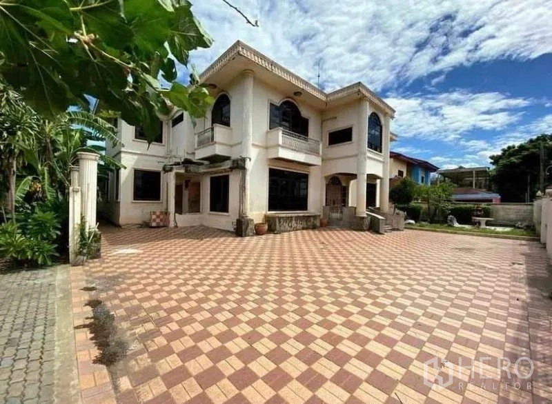 Detached House for sale in Prawet, Bangkok - Two-storey detached house facade with expansive checkered tiled forecourt.