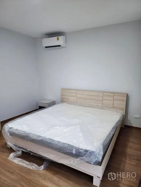 联排别墅 出租在Bang Phli, Samut Prakan - 极简风卧室，双人床、木地板与壁挂空调。