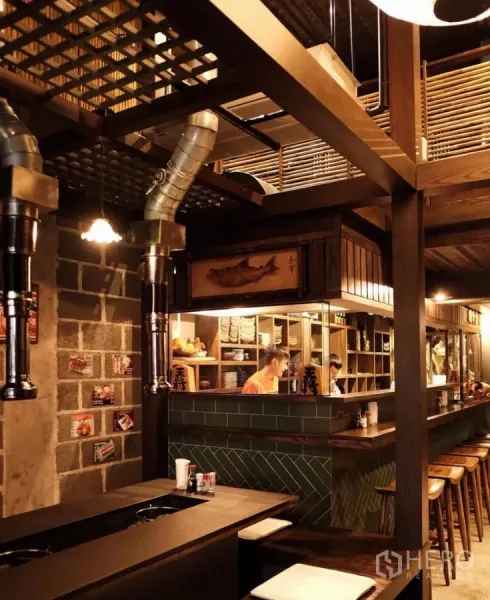 Shophouse for rent in Bang Rak, Bangkok - Open kitchen and bar counter with wooden stools and vintage décor inside the shophouse.