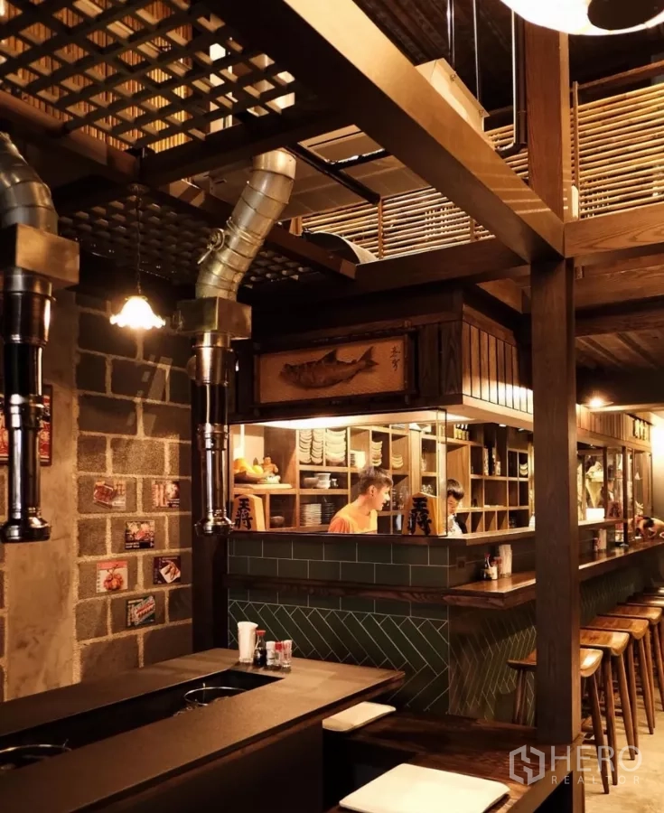Shophouse for rent in Bang Rak, Bangkok - Open kitchen and bar counter with wooden stools and vintage décor inside the shophouse.