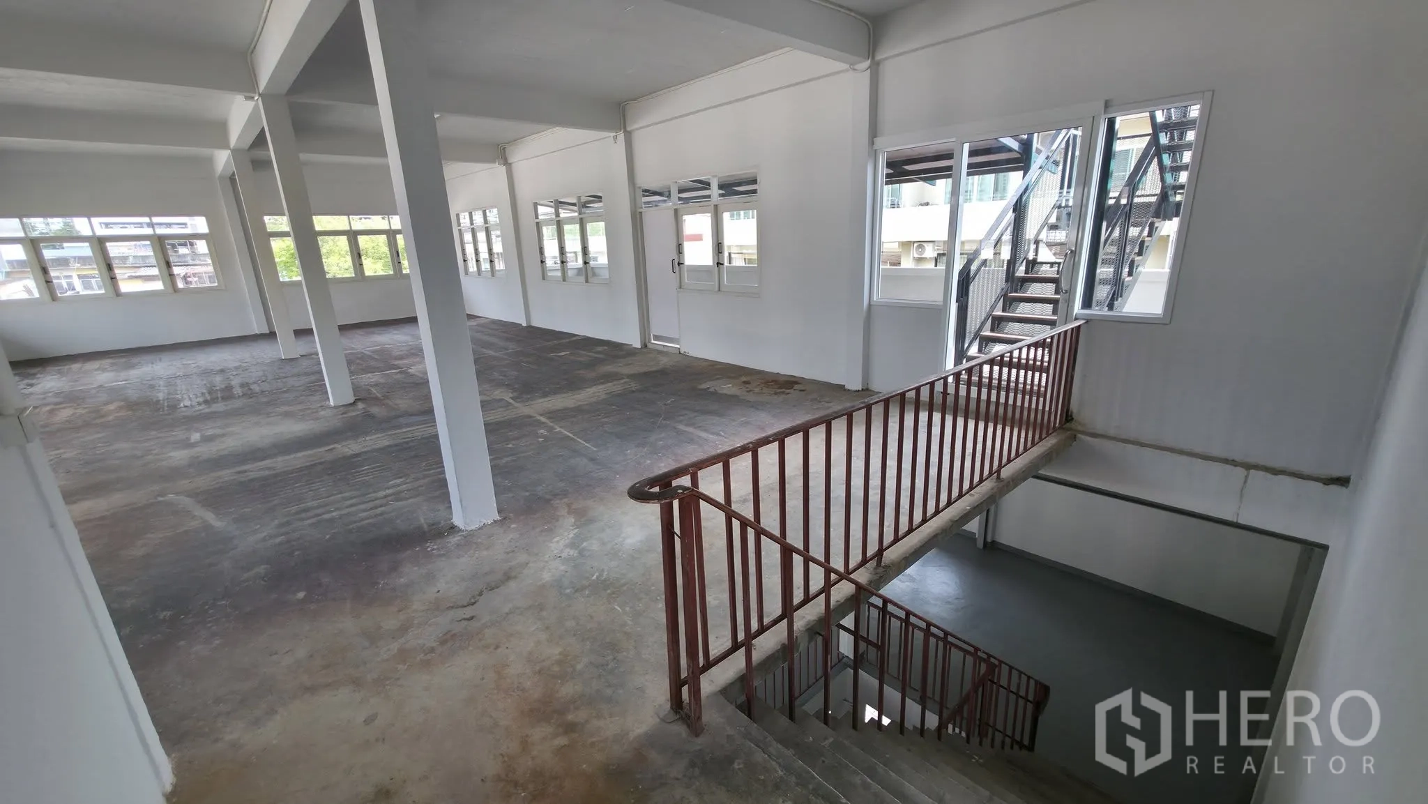 Warehouse for rent in Din Daeng, Bangkok - Warehouse level showing internal staircase, large windows, and access to an external stair.