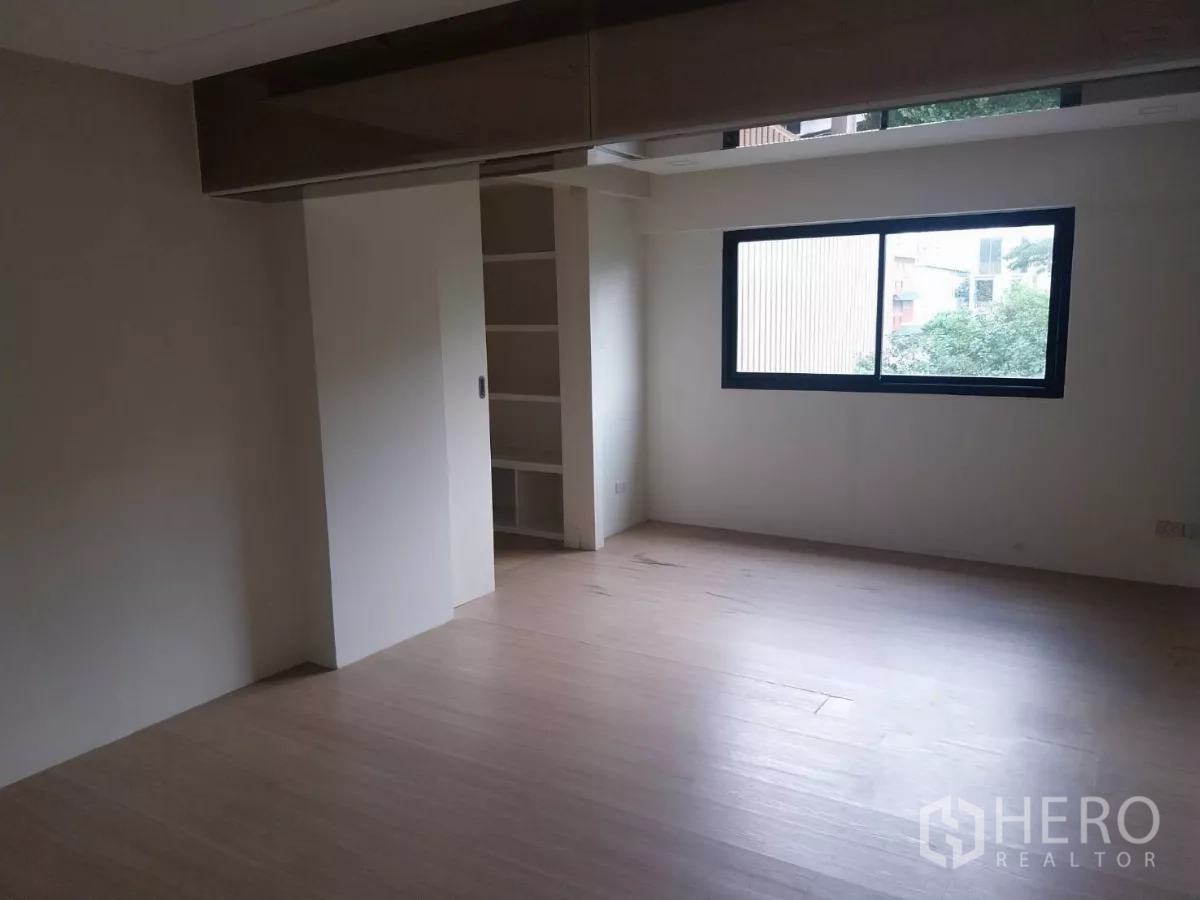 Retail Space for rent - Spacious mezzanine room with window and built-in shelving.