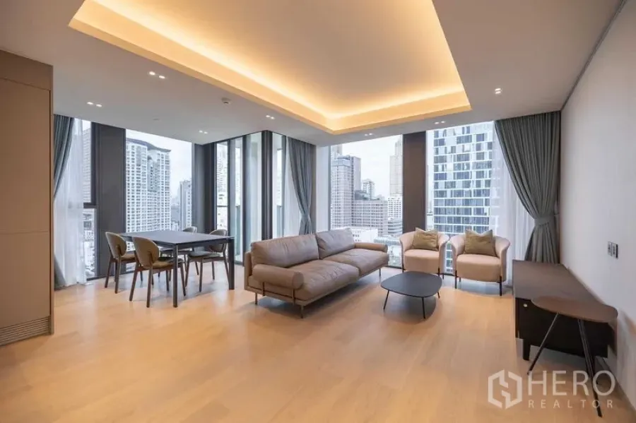 Condominium for rent in Pathum Wan, Bangkok - Spacious living room with recessed lighting, sofa set and wide urban views.