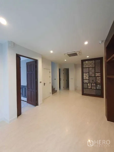 Detached House for sale in Prawet, Bangkok - Hallway with patterned partition, staircase, and recessed lighting.
