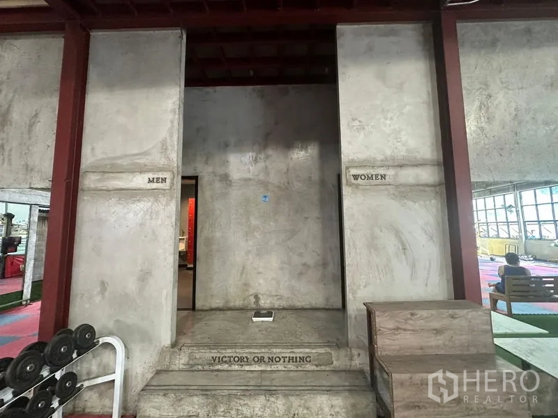 Warehouse for rent in Khlong Toei, Bangkok - Separate men and women restroom entrances in raw concrete finish.
