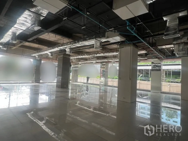 Retail Space for rent - Open-plan retail interior with polished tile floors, floor-to-ceiling windows and exposed ducting.