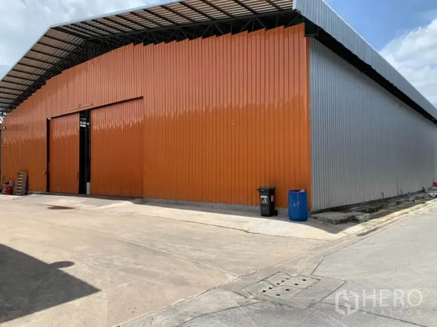 货栈 出租在Bang Kapi, Bangkok - 曼谷邦甲比仓库外观，橙色金属墙板与宽大推拉门，层高充裕。