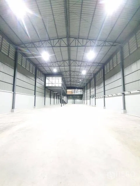 Warehouse for rent in Sai Mai, Bangkok - Empty warehouse aisle with high roof, bright LEDs, and vented side walls.