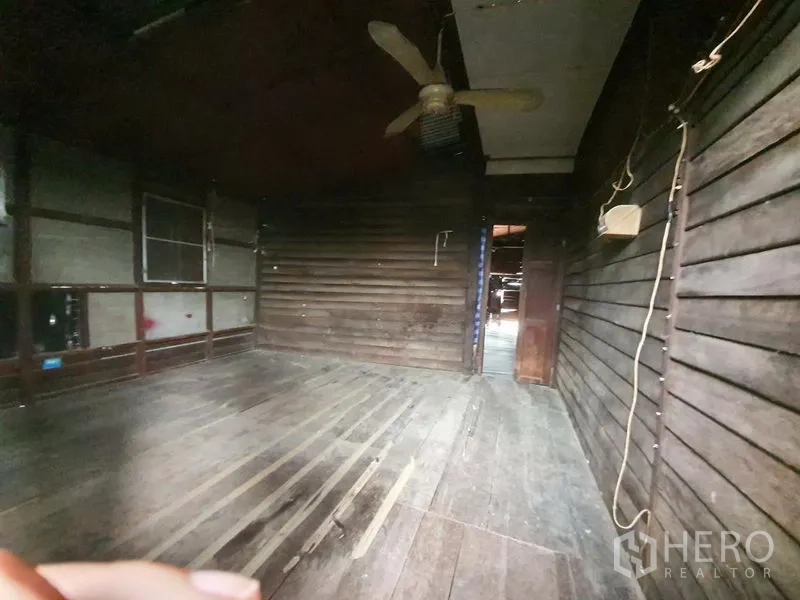 Detached House for rent in Sathon, Bangkok - Bedroom with wooden wall panels, plank floor and a ceiling fan.