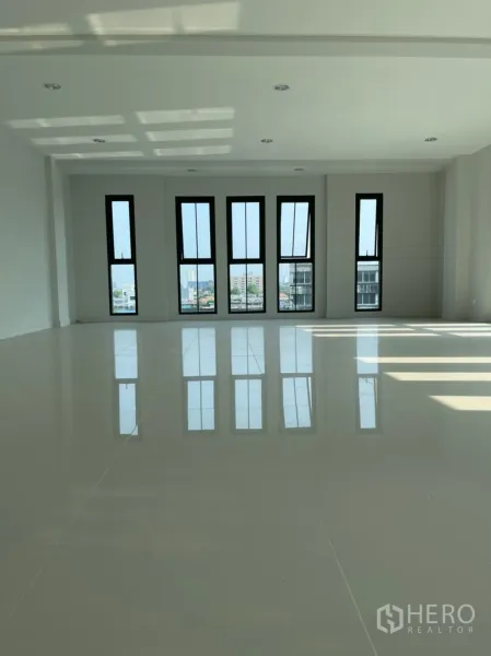 Home Office for rent in Suan Luang, Bangkok - Spacious upper floor featuring tall vertical windows and polished tile flooring.