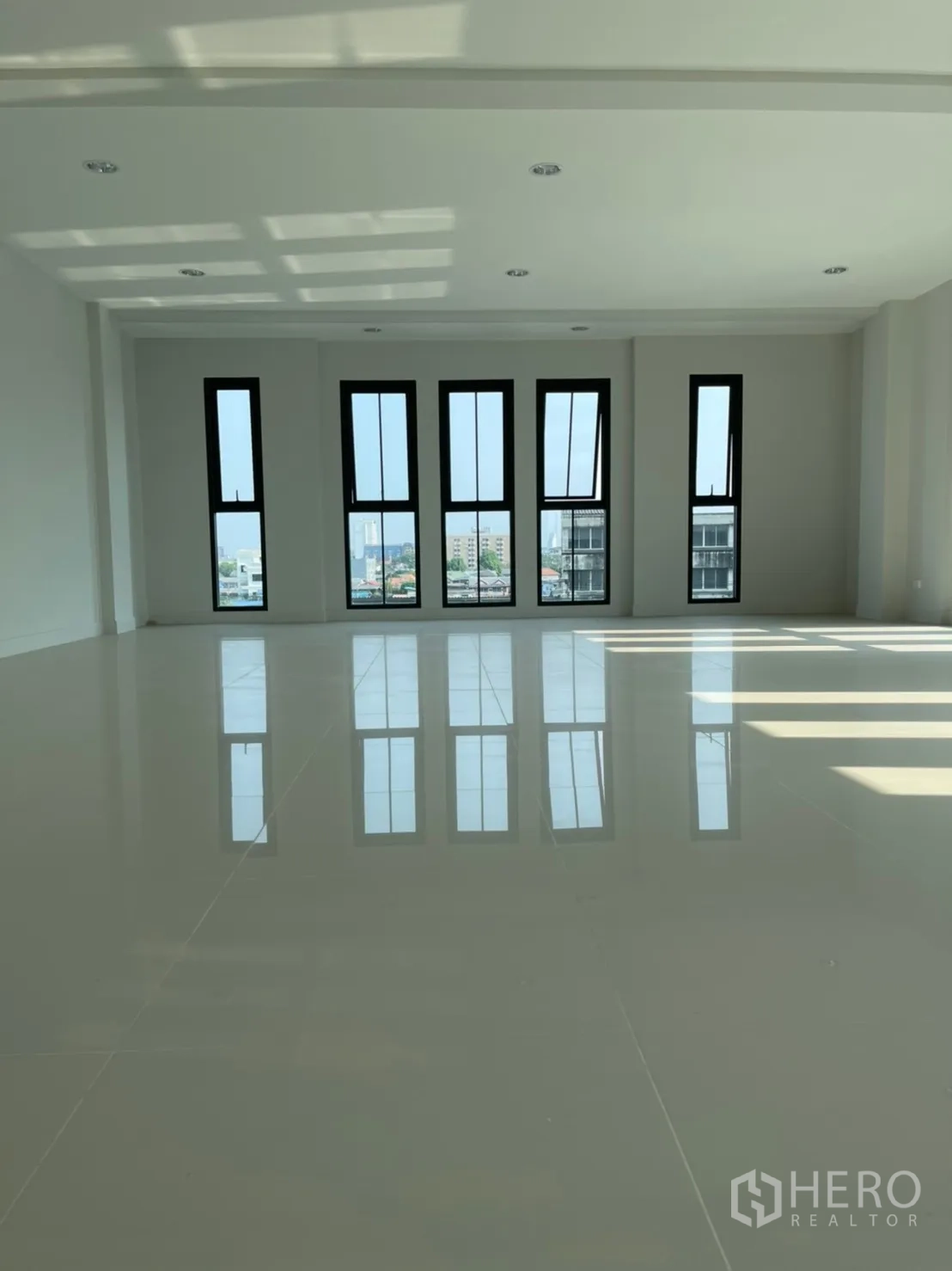 Home Office for rent in Suan Luang, Bangkok - Spacious upper floor featuring tall vertical windows and polished tile flooring.