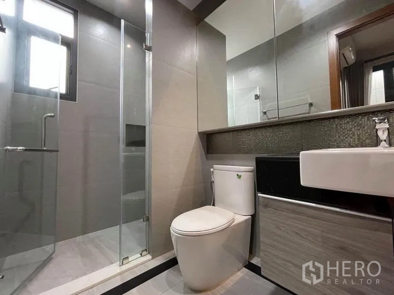 Detached House for rent in Bang Na, Bangkok - Contemporary bathroom featuring a glass shower enclosure, wall mirror and vanity.