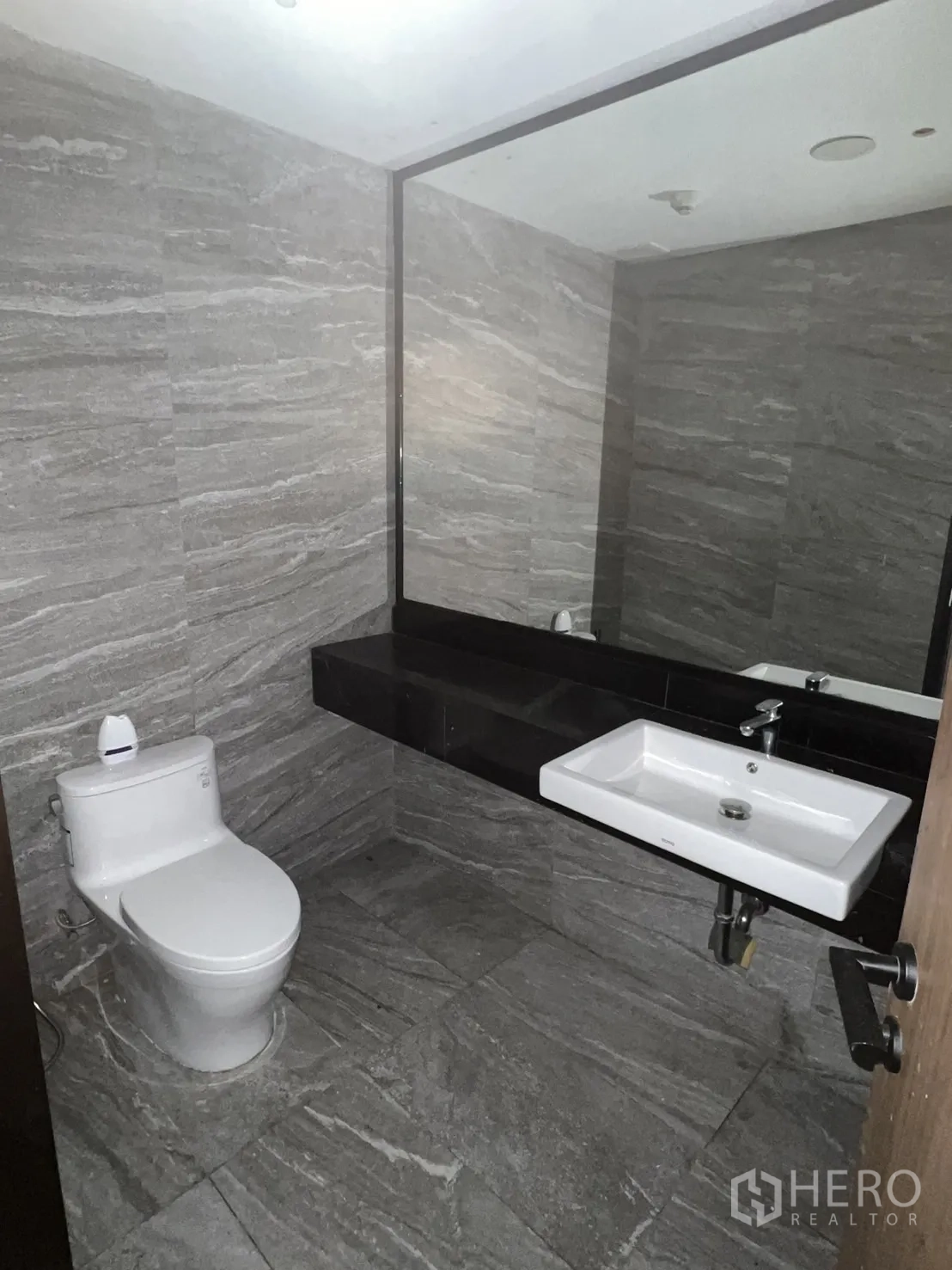 Retail Space for rent in Watthana, Bangkok - Second restroom with large mirror, stone-look tiles and white fixtures.