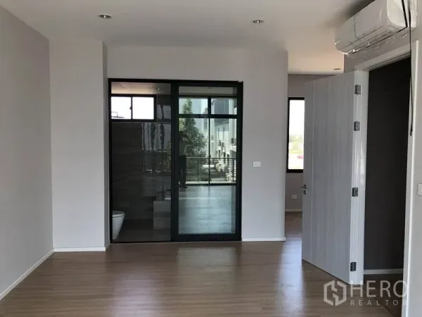 联排别墅 出租或出售在Saphan Sung, Bangkok - 采光充足的卧室，木地板，推拉玻璃门连通套内卫浴与空调