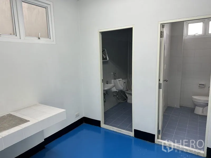工厂 出租在Khlong Luang, Pathum Thani - 员工卫生间区域，独立小便间与坐便间，蓝色环氧地坪。