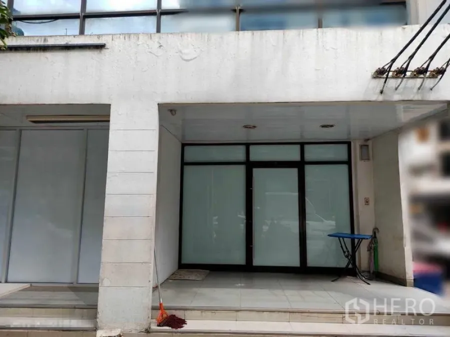Shophouse for rent in Watthana, Bangkok - Ground-floor shophouse frontage with frosted glass doors, tiled entry and a covered canopy in Bangkok’s Thonglor area.