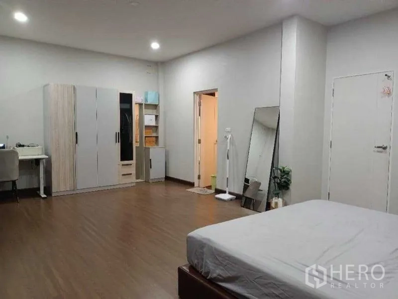 独立式住宅 出租在Mueang Nonthaburi, Nonthaburi - 宽敞卧室，设衣柜、书桌与套内卫生间门，木地板。