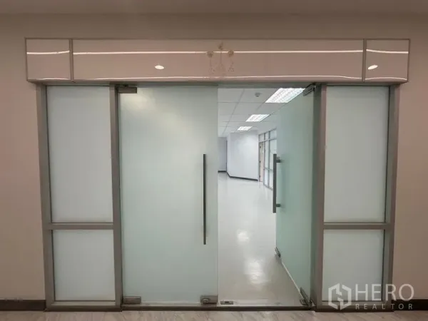 办公空间 出租在Bang Rak, Bangkok - 磨砂玻璃推拉门的办公入口，通向明亮的室内。