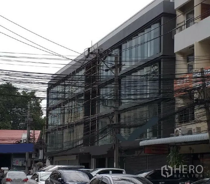 带办公室的家 出租在Khlong Toei, Bangkok - 现代低层商业建筑，整面玻璃立面，位于繁忙街道。