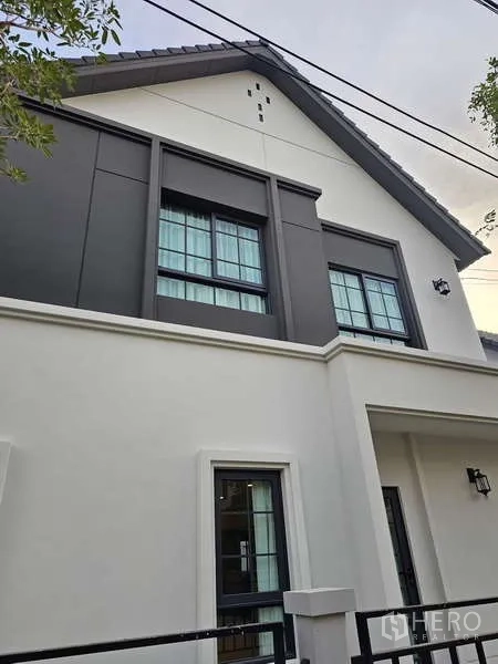 Detached House for rent in Bang Phli, Samut Prakan - Close-up of the upper facade showing tall windows and a grey-and-white gable.