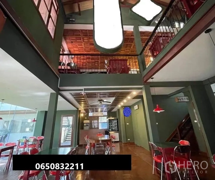 零售空间 出租在Pathum Wan, Bangkok - 双层挑高室内，带夹层、木质天花、吊灯与咖啡座位。