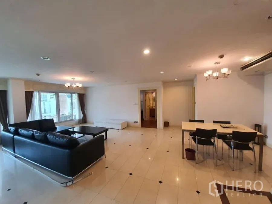 Condominium for rent in Pathum Wan, Bangkok - Spacious living and dining area with black leather sofa, chandeliers, and large windows in a Pathum Wan condo for rent.
