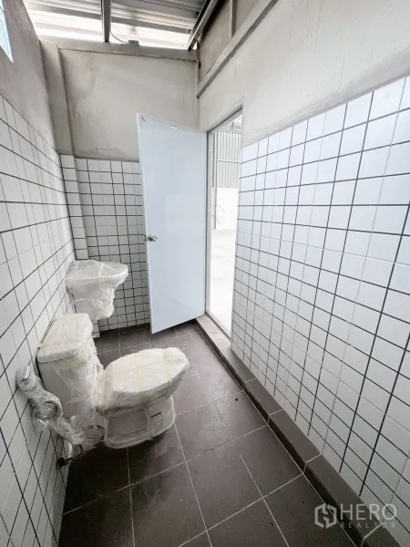 Warehouse for rent in Khlong Luang, Pathum Thani - New tiled restroom with two toilets inside the warehouse.