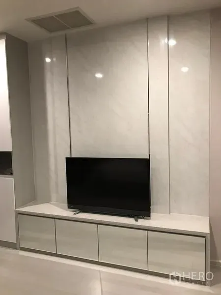 Condominium for rent in Pathum Wan, Bangkok - Living area with sleek TV console and marble accent wall