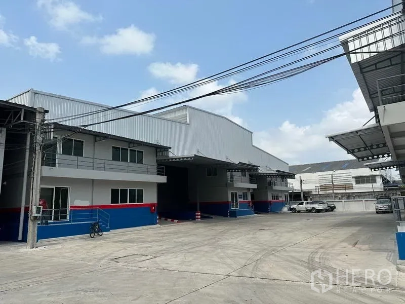 Warehouse for rent in Samut Prakan - Row of warehouses with covered truck access and parking areas inside the compound.