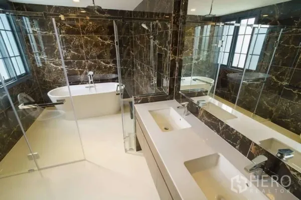 Detached House for rent or sale in Bang Phli, Samut Prakan - Luxury bathroom with double vanity, glass shower and freestanding bathtub with marble walls.