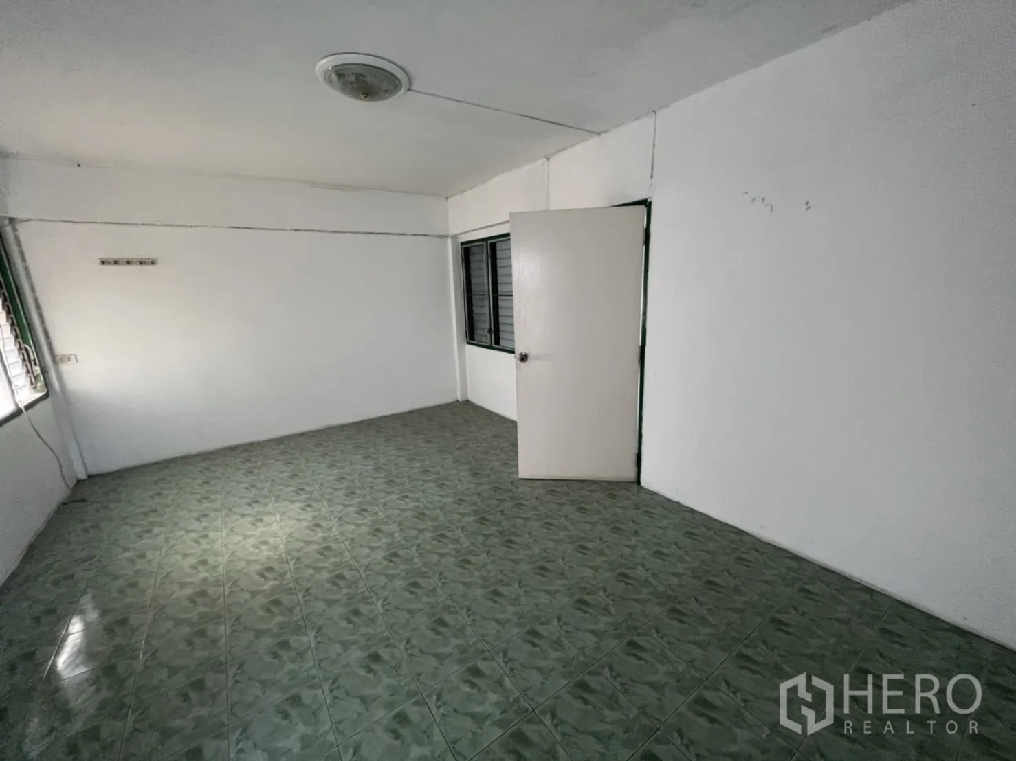 联排别墅 出售在Watthana, Bangkok - 宽敞房间，设门与转角窗，绿色瓷砖地面。