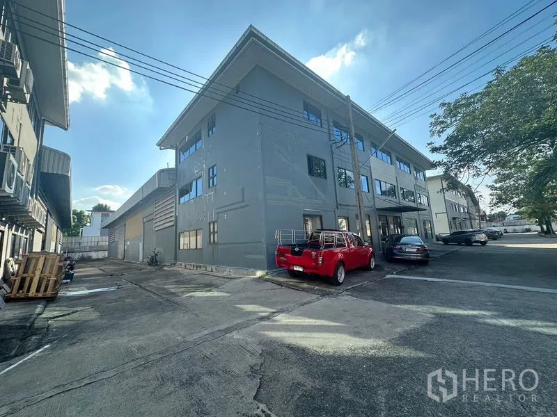 Warehouse for rent in Saphan Sung, Bangkok - Rear angle of warehouse complex with driveway and parking bays.