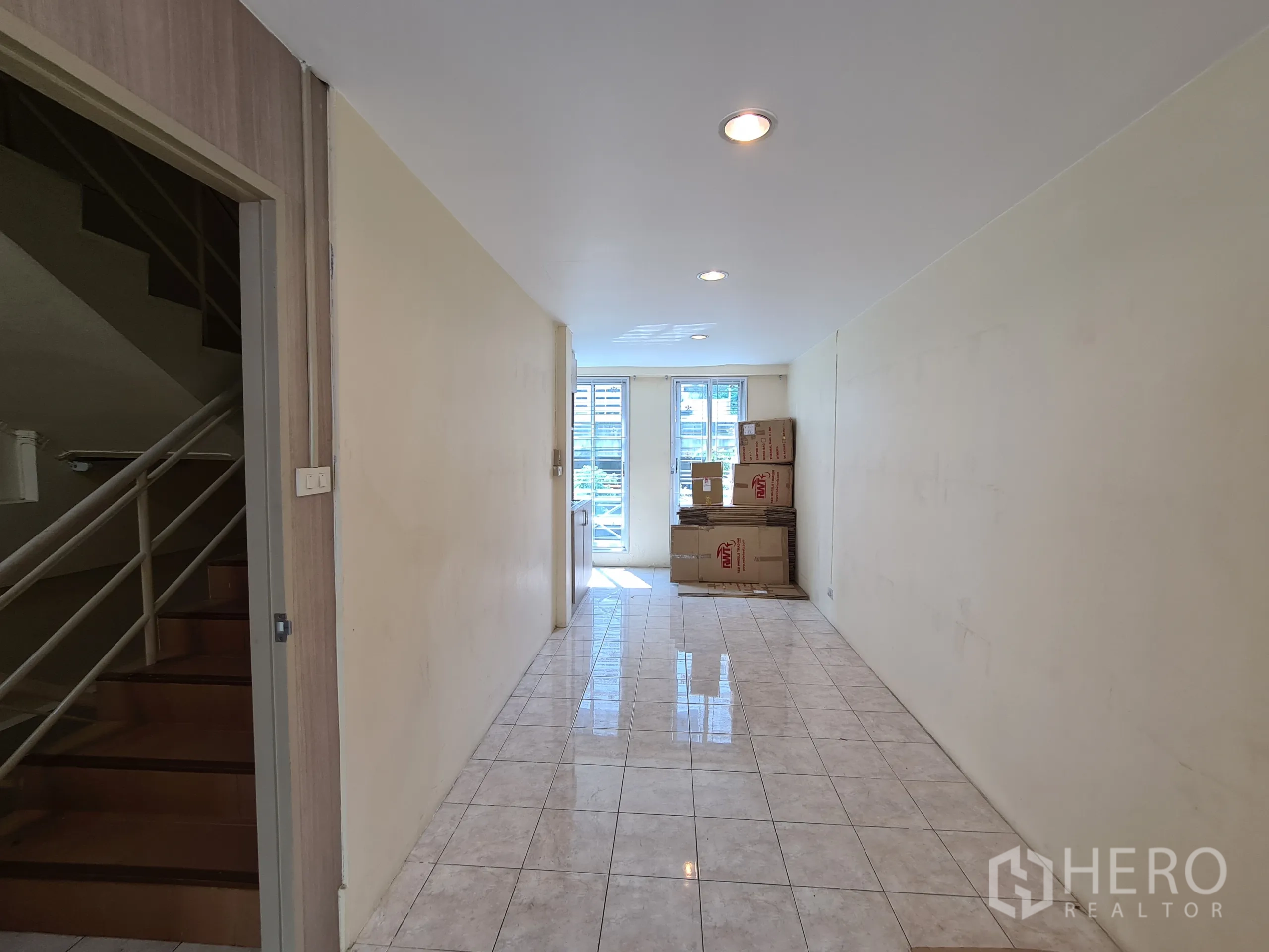 Shophouse for rent or sale in Sathon, Bangkok - Tiled entry hall with staircase to upper floors and a glass back door.