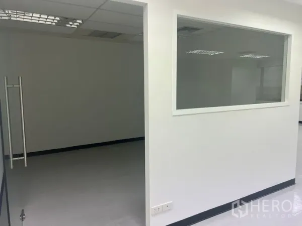 Office Space for rent in Watthana, Bangkok - Partitioned office area with an internal window and ceiling lights.