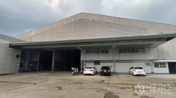 Factory for rent in Khlong Toei, Bangkok - Front elevation of warehouse showing covered loading bays and expansive parking apron.