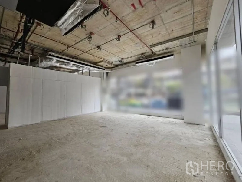 Retail Space for rent - Open-plan shop space with concrete floor, large corner glazing, and abundant natural light.