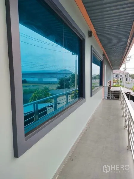 Factory for rent in Ban Phaeo, Samut Sakhon - Second-floor balcony with metal railing overlooking industrial neighborhood.