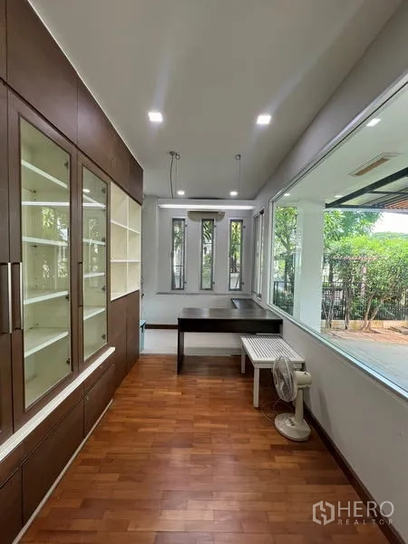 Detached House for rent in Bang Kapi, Bangkok - Home office with display cabinets and picture windows facing the yard.