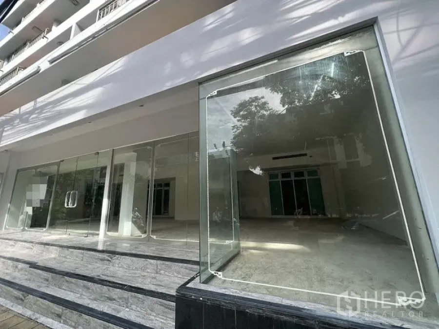 Retail Space for rent - Street-level storefront featuring a wide glass facade and raised stone steps.