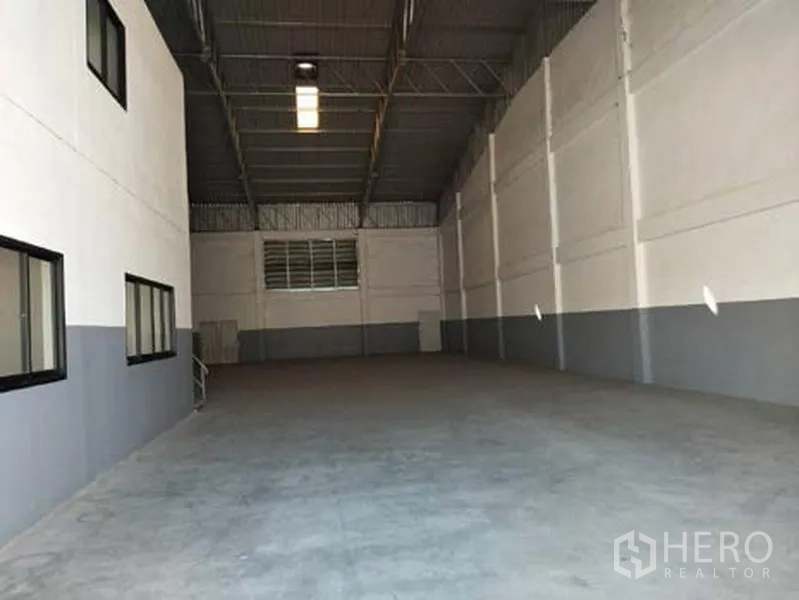 Factory for rent in Bang Phli, Samut Prakan - Spacious high-clearance factory interior with concrete floor, steel truss roof, and side windows in Bang Phli.