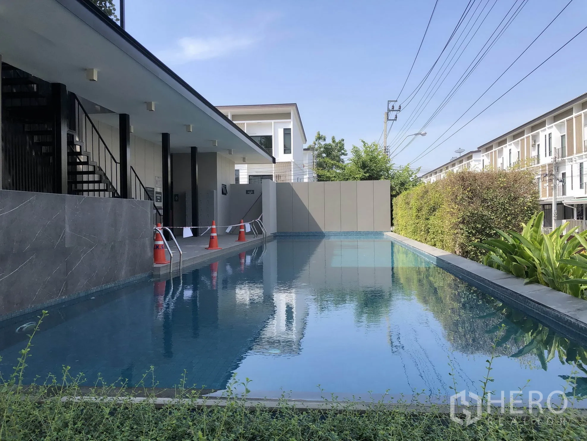 Townhouse for rent in Bang Kapi, Bangkok - Communal swimming pool and clubhouse surrounded by hedges within the townhouse estate.